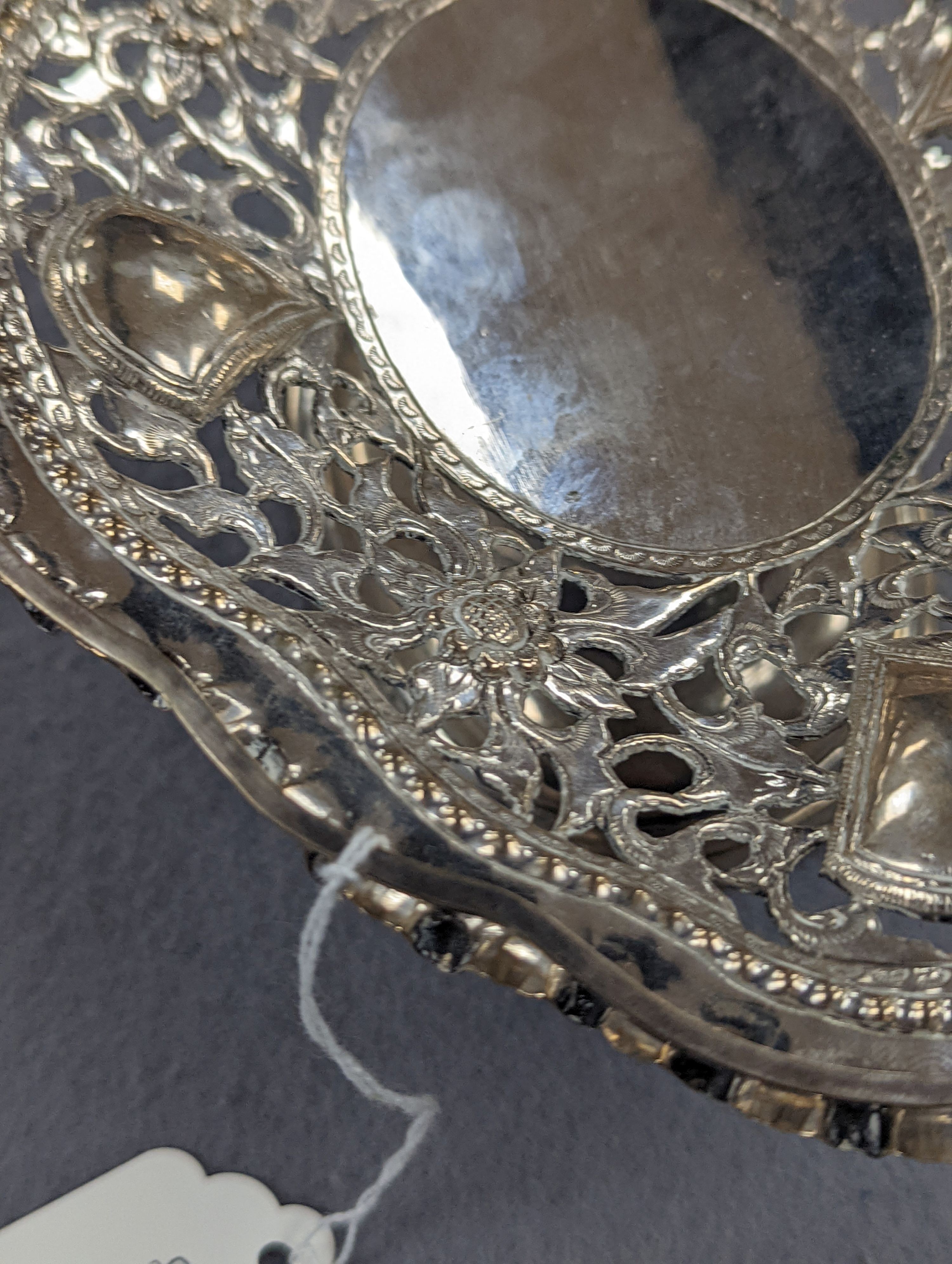 A Chinese pierced and embossed white metal shaped oval pedestal basket, length 21.6cm, 9oz, signed on base.